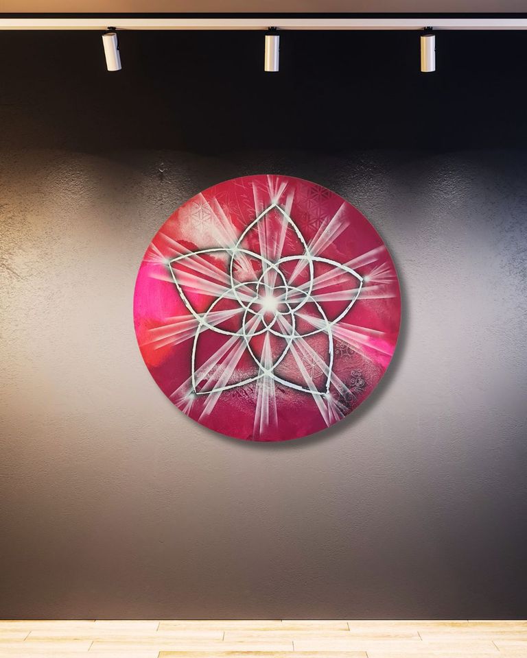 Rundes Kunstwerk mit einer stilisierten Venusblume in Weiß vor einem tiefroten Hintergrund, beleuchtet an einer grauen Wand unter drei Deckenstrahlern.